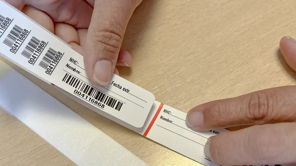 Enfermera desprendiendo etiqueta de muestra de pulseras identificacion transfusional hospitales