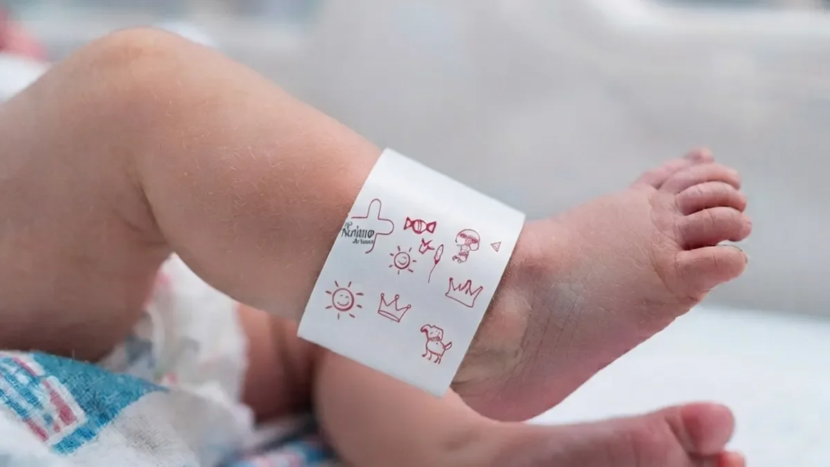 Detalle de pulsera pediátrica suave colocada en el tobillo del recién nacido